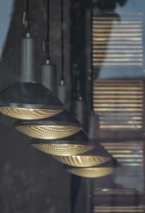 Hanging industrial-style lighting fixtures arranged in a linear pattern