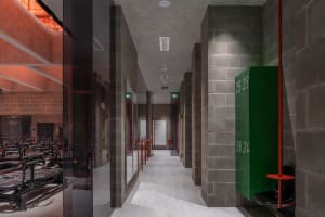 Interior view of a gym with industrial-style brick walls, concrete floor, and glass partitions.