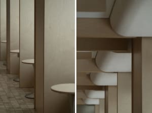 A minimalist cafe interior with wooden tables and walls.