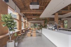Modern, minimalist coffee shop interior with concrete finishes and a sleek white bar.