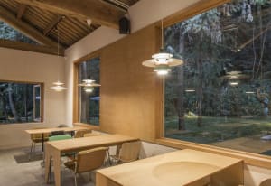 A modern coffee shop with wooden desks and large windows