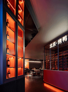 A modern restaurant interior showcasing metallic accents and a brick wall.