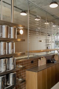 Industrial-style cafe with metal bins, wooden shelves, and concrete ceiling