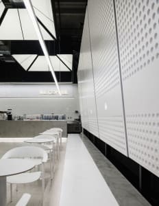 Modern coffee shop with minimalist design, white materials and bar counter.