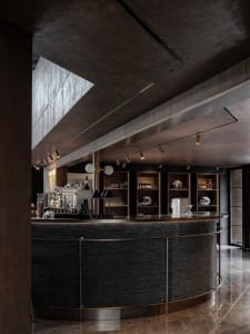 Industrial-style bar with concrete and metal finishes, featuring modern design elements and minimalistic aesthetic.