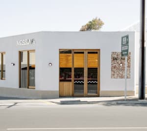 A minimalist storefront with a concrete exterior and large windows.
