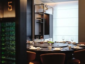 A minimalist restaurant with wooden furniture and round dining table.