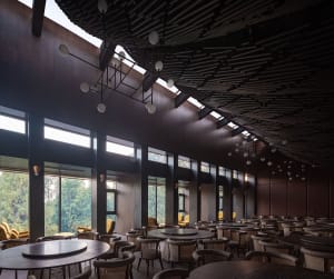 Industrial-themed restaurant interior featuring wood materials and high ceilings with skylights.