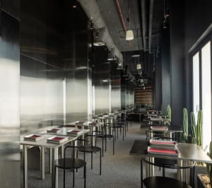 Modern, minimalist restaurant interior with metallic countertops and chairs.