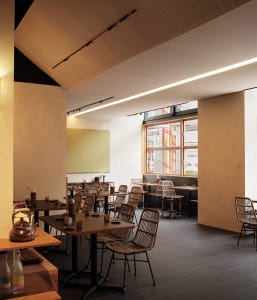 A minimalistic restaurant interior featuring wood and metal elements.