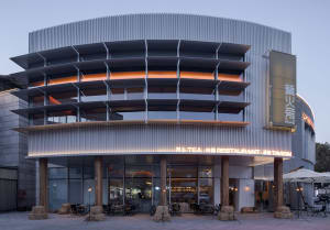 A modern restaurant exterior with metal cladding and illuminated signage.