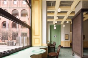 A cafe interior designed in a modern industrial style, featuring clay tiles and wooden furniture.