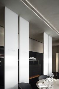 Decorative white panels in a modern restaurant interior with dark wood accents.
