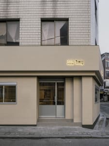 Modern retail storefront with concrete facade and glass doors.