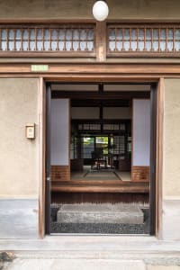A traditional Japanese entryway featuring a wooden door and interior design.