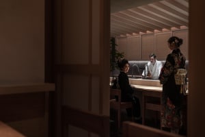 A traditional Japanese kitchen with wooden furniture, bamboo accents, and light tiles, featuring a modern design with a mix o