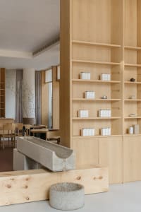 A minimalist retail space featuring wooden shelves with products displayed.