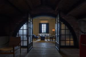 Interior design featuring a minimalist living room with brick arches and glass doors.