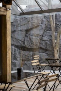 A cafe interior featuring modern wood and stone elements.