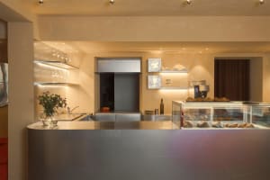 Modern minimalist cafe interior with a sleek metal countertop.