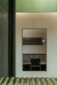 Restaurant interior featuring green structural materials and modern design elements.