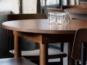 Close-up of a wooden table in a modern restaurant interior.
