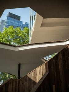 Modern staircase with wooden steps and glass railings.