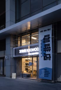 Storefront with blue signage and a white awning, featuring a modern minimalist design.