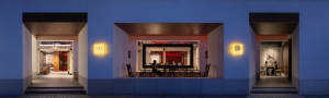 An exterior view of a coffee shop illuminated by luminous materials.