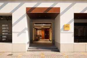 Modern minimalist coffee shop entrance with concrete walls and floor.