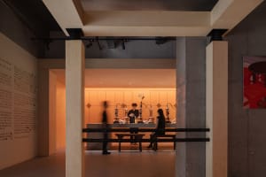 A minimalist experience center with modern wooden and concrete structural elements.