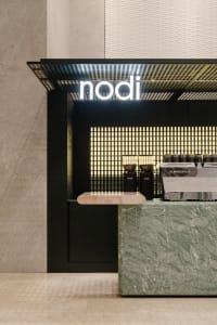 Minimalist design of a coffee shop counter with marble top and sleek, modern aesthetics.