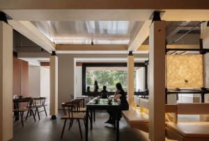 Interior of a modern restaurant featuring wood, concrete, and glass materials.