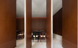 A minimalist restaurant interior with wooden walls and flooring.