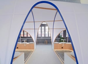 Modern restaurant interior with white tiled walls and blue accents.