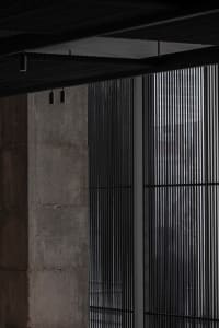 Concrete wall with modern grid pattern and overhead lighting