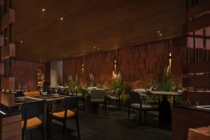 A modern restaurant interior with wooden walls, concrete finishes, and glass elements.