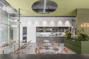 A minimalist cafe interior with metal, glass, and concrete features.
