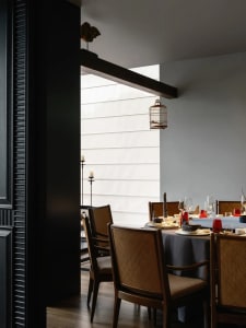 Industrially designed restaurant dining room with wooden furniture and a birdcage hanging from the ceiling.