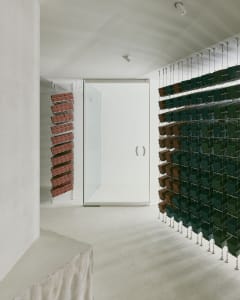 A minimalist interior design featuring concrete walls and metal shelving units.