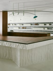 A minimalist retail store interior featuring a modern concrete countertop with a wooden base.