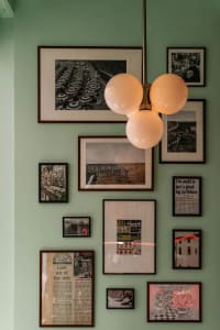 A wall adorned with framed photographs in a restaurant interior.