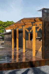Modern industrial rooftop food kiosk with wooden structure and metal roof.