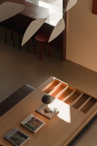 A modern home office desk with a minimalist lamp and books.