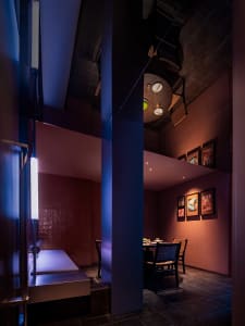 Modern minimalist restaurant interior with brick walls and warm lighting.