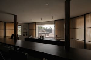 A minimalist, modern coffee shop bar counter made from wood and cloth materials.