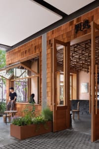 A modern coffee shop with wooden interiors and green plants