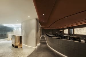 A modern restaurant interior featuring concrete walls and flooring.