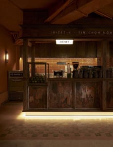 A modern coffee shop counter made of wood with a sign that says 'ORDER'.