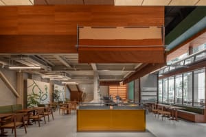 Interior view of a modern restaurant/cafe with wood accents and open seating areas.